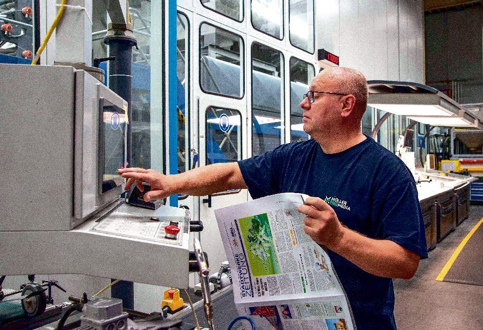 22 . 02 . 2023 , Brandenburg / Ahrensfelde : Druckerei Möller Pro Media GmbH . Foto : Ein Maschinenführer kontrolliert die korrekte Falzung und Seitenformatierung .